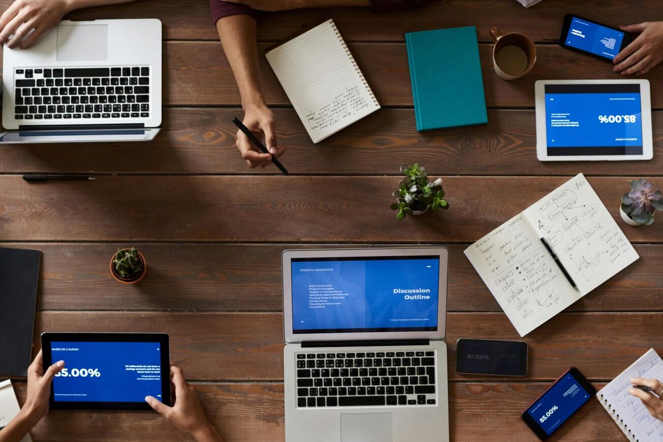 a group of people sitting around a table working on computers
